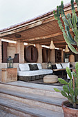 Blick auf überdachte Terrasse mit eleganten Sitzmöbeln