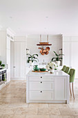White center block with green bar stools in an open kitchen