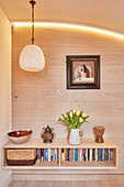 Floating sideboard mounted on board wall below arch with indirect lighting