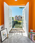 View of river through open balcony doors in bright orange wall