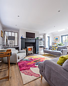 Grey sofa set around brightly coloured rug in living room