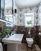 Tapete mit Savannen-Motiv und dunkler Marmor in der Toilette