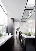 Schwarz-weiße Designerküche mit Kücheninsel in offenem Wohnraum