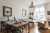 Rustic dining table and pale sofa set in room with white walls