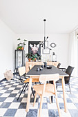 Different chairs around dining table on chequered floor
