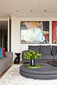 Grey sofa set, designer coffee table and large photos on wall in elegant lounge