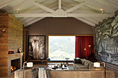 Elegantes Wohnzimmer mit Kamin und Holzverkleidung, Panoramafenster mit Landschaftsblick
