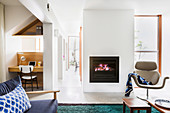Armchairs in front of a fireplace and integrated home office in an open living room