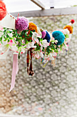 Garland of pompoms, fabric remnants and fabric flowers