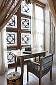 Schreibtisch vor einem Fenster mit orientalischen Fensterläden