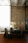 Dark dining table and antique chairs in industrial building