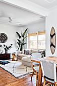 View past dining table into living room with ethnic accessories and houseplants