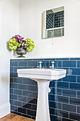 Vintage-style sink against wall tiled to half height with ledge