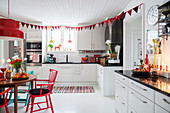 Red Christmas decorations in white kitchen-dining room