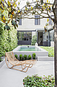 Rattan lounger on concrete terrace with pool in background