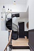 Black spiral staircase in white stairwell