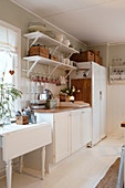 White table, kitchen counter and fridge in rustic kitchen