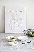 Handmade decorative bowls with lama motifs in front of framed drawing