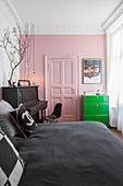 Rosafarbene Wand und Kassettentür im Altbau-Schlafzimmer