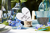 Summery table decoration with blue flowers and heart card with welcome greeting