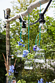 Creative garden lighting with hanging flower vases and fairy lights