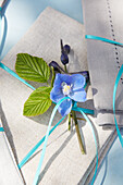Napkin decorated with blue delphinium flower and blue ribbon