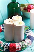 DIY-Adventskranz aus Stoffresten mit drei brennenden Kerzen