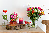 Late summer bouquets, log board and candle on wooden table