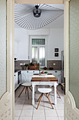 Transparente Stühle am Tisch in der Küche mit Designerleuchte