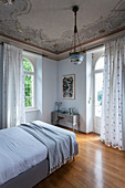 Ceiling fresco in bedroom with arched windows