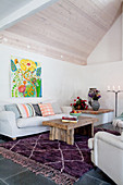 Colourful picture above in living room with exposed roof structure