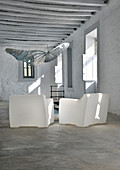 Two white plastic armchairs in traditional Greek house