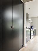 Fitted cupboards with leather handles and kitchen counter in background