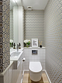 Narrow guest toilet with patterned wallpaper