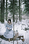 Woman drinking tea in snowy woods