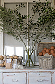 Olive branches in vase and basket of bath bombs