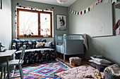 Hellblaues Kinderbett, Sofa und Spieldecke im Babyzimmer