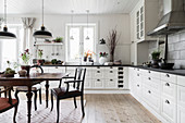 Antique dining table and chairs in white kitchen-dining room