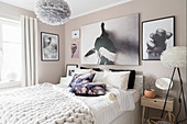 Beige and white bedroom with monochrome photos above bed
