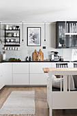 White kitchen counter with black worksurface and dining area in kitchen