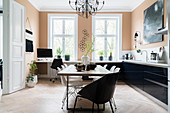 Essbereich mit weißen Klassikerstühlen, Küchenzeile und Home Office in heller Wohnküche