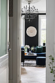 View through open door into elegant living room with black wall and black and white accessories