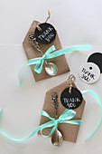 Round tags and tiny silver spoons decorating small envelopes