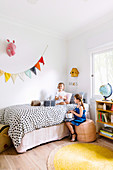 Two girls with wrapped presents in children's room