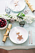 Laid table with crackers and a sprig of flowers in the middle