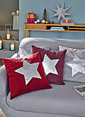 Homemade cushions with silver stars for Christmas on a sofa
