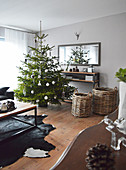 Decorated Christmas tree, baskets next to sideboard and wall-mounted mirror in living room