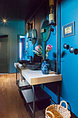 Washstand with twin sinks against blue wall in hall