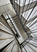 Concrete staircase with metal banisters in stairwell (view from top)