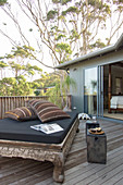 Exotisches Tagesbett mit schwarzer Matratze auf der Terrasse